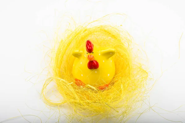 Pollo amarillo, sobre fondo blanco. Vista desde arriba. Acostado. Pájaro amarillo en una canasta. Una polla graciosa. Semana Santa . — Foto de Stock