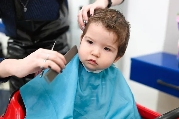 Дитина в перукарні крупним планом. Перша стрижка дитини в перукарні. Дитяча стрижка малюк . — стокове фото