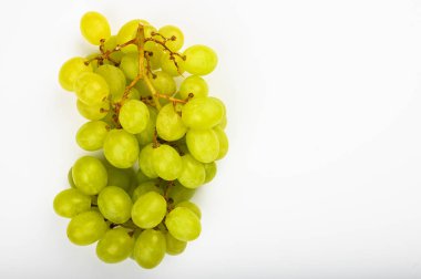 Beyaz arka planda büyük yeşil sulu üzüm. Düz yatıyordu. Yukarıdan bak. Yazmak için yer var. Bir demet yeşil üzüm