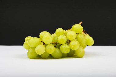 Siyah beyaz arka planda bir demet üzüm. Yeşil üzümler.