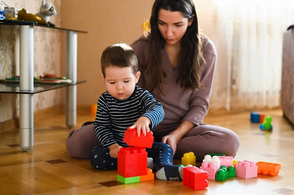 妈妈用玩具培养她的孩子.未来的建设者男孩和妈妈玩玩具 — 图库照片