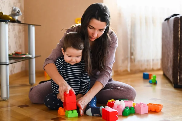 Designerspel mamma och barn. Baby pojke och mor leker tillsammans med konstruktion uppsättning leksak — Stockfoto