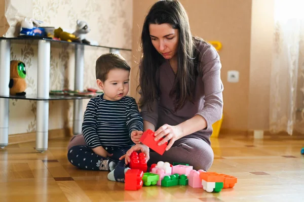 Designer-Spiele Mutter und Baby. Junge und Mutter spielen zusammen mit Bauset-Spielzeug — Stockfoto
