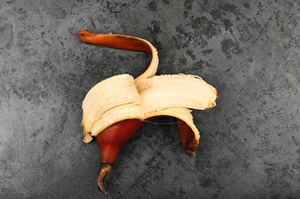 Red bananas on a dark background. Red bananas are shorter, a kind of banana. Brown banana variety.