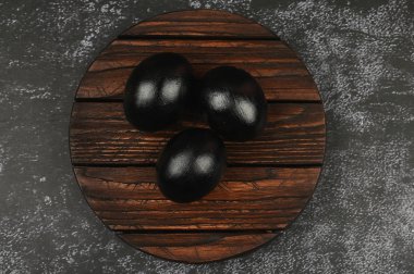 Karanlık bir arka planda siyah yumurtalar. Düz yat. Kara Paskalya. Üç siyah yumurta.