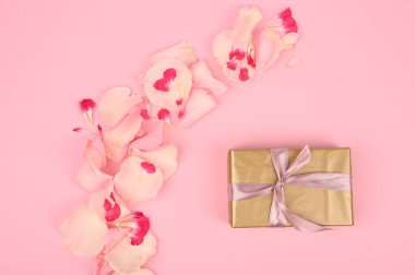 Güzel çiçekli düz kompozisyon ve pembe arka planda hediye kutusu. Metin için boşluk