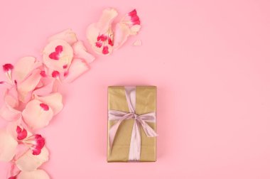 Güzel çiçekli düz kompozisyon ve pembe arka planda bir hediye kutusu. Metin için boşluk