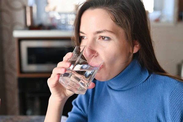 Drink plenty of water from the virus, Covid-19 Pandemic Coronavirus. Girl drinks water from a glass.