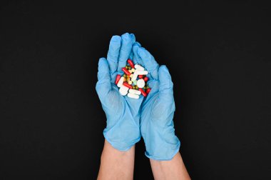 Bir sürü ilaç, kapsül ve tablet yakın plan tıbbi eldiven içinde doktor elinde. Coronavirus tabletleri kavramı.