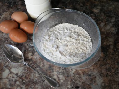 Un, yumurta, süt. Pişirme malzemeleri. Misket masasında kaşık. Yemek hazırlığı