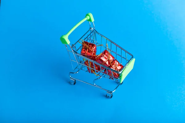 Christmas presents shopping concept. Basket and christmas accessories. Christmas basket with presents. Onlain shopping. On a blue background. place for writing