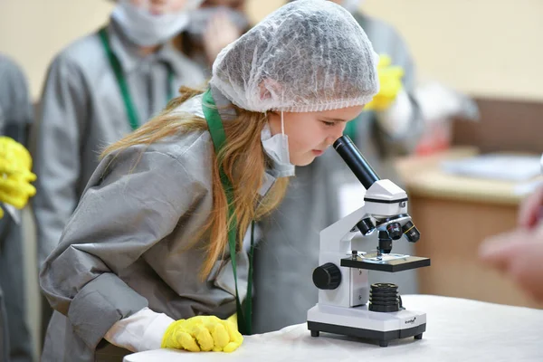 Bebek mikroskoptan bakıyor. Tıp öğretiyorum. Hastanedeki bir seminerde genç doktorlar. Çocuk ve tıp KHARKIV, UKRAINE - 20 HAZİRAN, 2020.