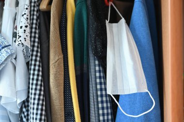 Yüz maskesi ve gardırop. Kıyafetler için bir gardırop ve solunum maskesi. koronovirüs konsepti.