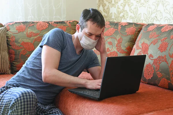 Stay at home concept. Quarantine due coronavirus pandemic. Business man working from home, wear a protective mask. Remote work.