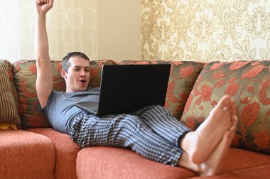 Genç adam koronavirüs karantinası sırasında bilgisayar oyunu oynuyor. Covid-19 kendini izole etme kavramı.