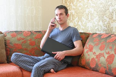 Ev konseptinde kal. Koronavirüs salgını nedeniyle karantina. Evden çalışan bir iş adamı, koruyucu bir maske takıyor. Uzak çalışma. 