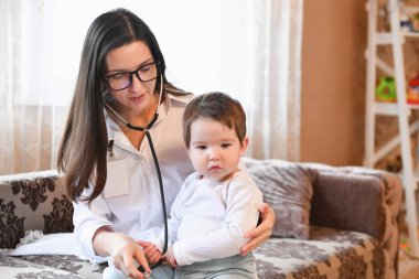 Doktor, bebeğin nefesini dinler. Tıp, sağlık ve pediatri konsepti - steteskoplu kadın doktorların hastaların kalp atışlarını ya da evdeki nefeslerini dinlemeleri.