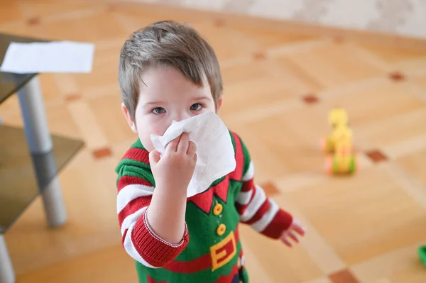 Child suffering from running nose or sneezing. Allergic little boy.