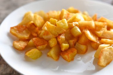 Beyaz tabakta kızarmış altın patates. Kızarmış patates dilimleri..