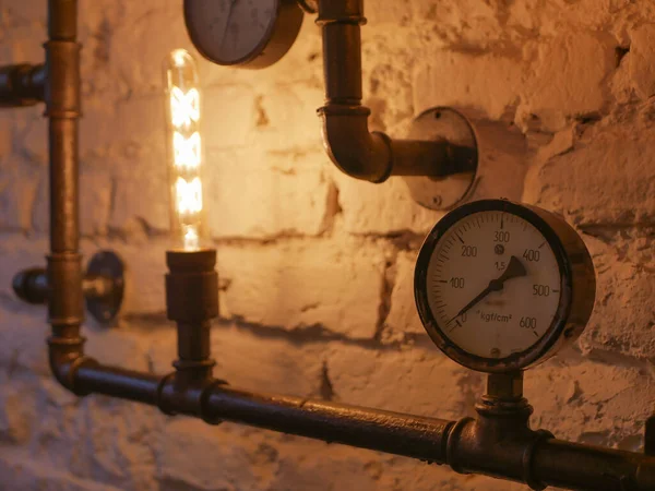 loft style decor With iron pipes. and incandescent lamps. Loft style wall and steampunk pipes.