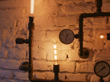 Çatı katı dekoru ve demir borular. Parlak ışık veren güneşi varettik; Çatı katı tarzı duvar ve steampunk borular.