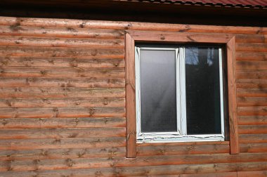 Ahşap arka planda plastik pencere. Evde plastik pencere var.