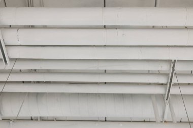 Tavanda beyaz borular ısıtılıyor. Isıtma sistemi..