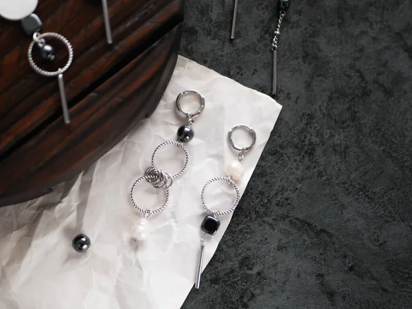 A set of silver jewelry in the dark.