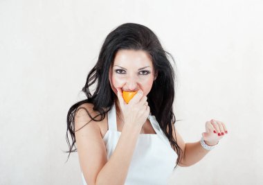 Kız portakalı ısırıyor. Portakallı bir kızın portresi.