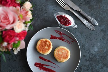 Peynirli krep ve reçel. Çiçekli gri bir arkaplanda