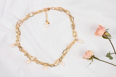 Beyaz bir kağıt üzerinde altın kadın zinciri.