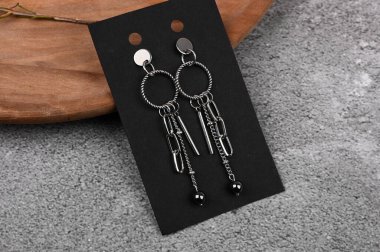 Siyah arka planda gümüş kadın küpeleri. Siyah bir kağıt üzerine serilmişti..