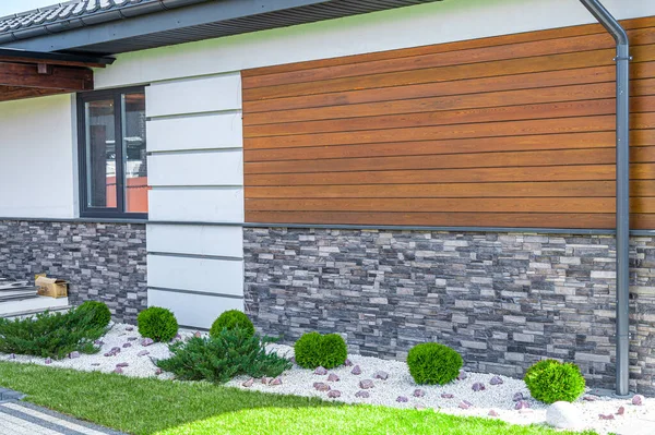 cladding of a house made of wood and decorative brick.