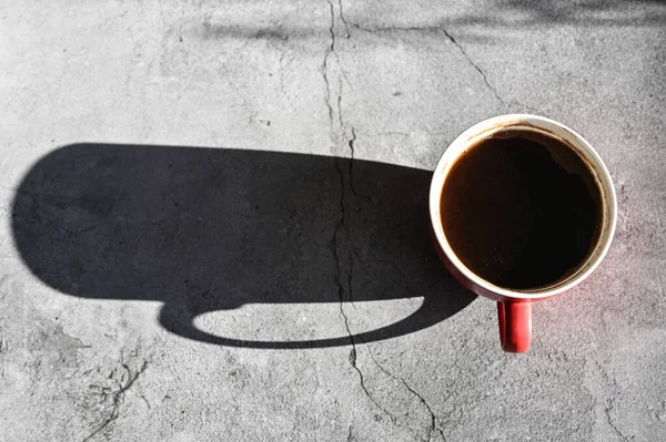 red cup with a shadow. Long shadow from a cup of coffee.