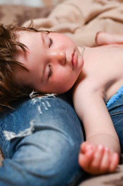 Bebek annesinin kucağında uyuyor..