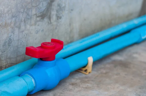 PVC ball valve in the water supply pipe line beside the concrete wall