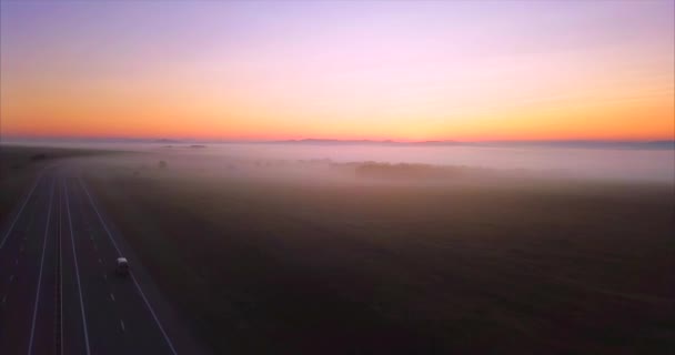 Vista aérea de la carretera con coche de conducción, campos de la mañana cubiertos de niebla. Rusia — Vídeos de Stock