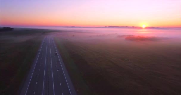 Vue aérienne de la route avec des voitures, champs couverts de brouillard au lever du soleil. Russie — Video