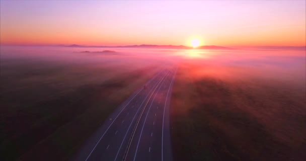 Вид с воздуха на дорогу с автомобилями, поля покрытые туманом на восходе солнца. Россия — стоковое видео