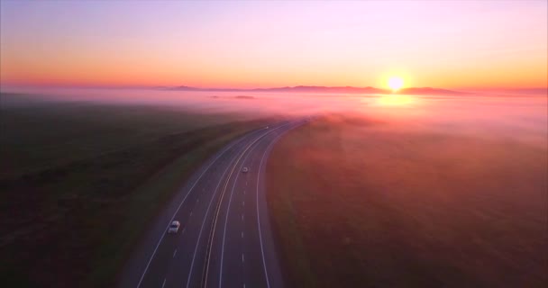 フィールドの車と道路の空撮は、日の出に霧で覆われて。ロシア — ストック動画