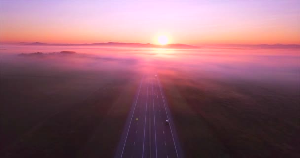 Вид с воздуха на дорогу с автомобилями, поля покрытые туманом на восходе солнца. Россия — стоковое видео