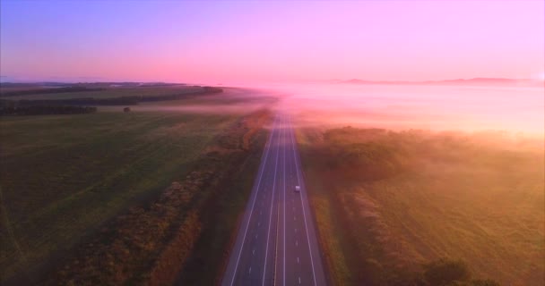 Descendiendo por encima de la carretera con coches, campos cubiertos de niebla por la mañana. Rusia — Vídeos de Stock