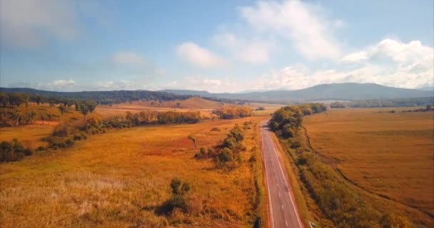 Vliegen boven de lege snelweg, de velden van de ochtend en de heuvels aan de horizon. Rusland — Stockvideo