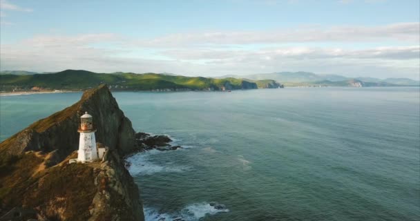 Lentamente voando perto de penhasco rochoso com farol. Seashore está no fundo. Rússia — Vídeo de Stock