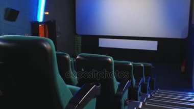 Satırlardaki mavi sinema koltukları ve boş sinema salonu büyük ekran görünümü