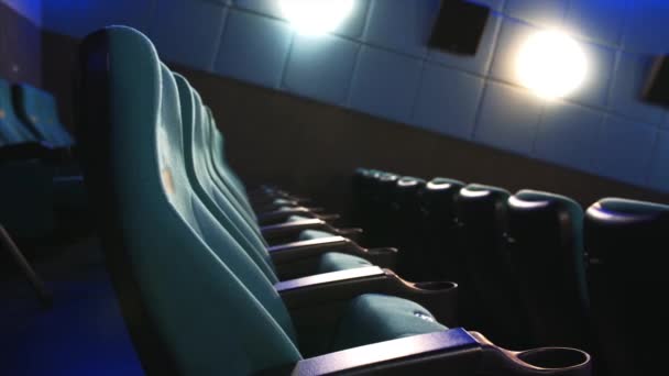 Close view of cinema seats in rows in empty hall. Camera is sowly sliding — Stock Video