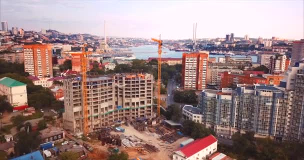 Zoom aéreo en vista de la casa bajo constancia, grúas de trabajo en el centro de la ciudad — Vídeos de Stock