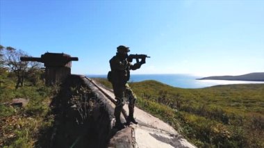 Eski bunker üzerinde duran ve tüfeği ile nişan Modern asker. Alan