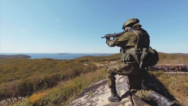 Soldier on knee aiming and searching the enemies. Seascape — Stock Video