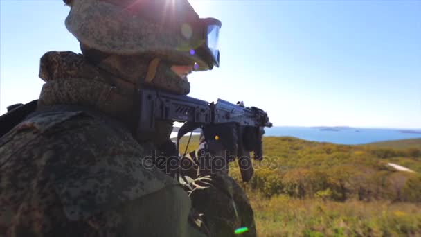 Военный в современной форме. Солдат целится вдаль. Поле — стоковое видео